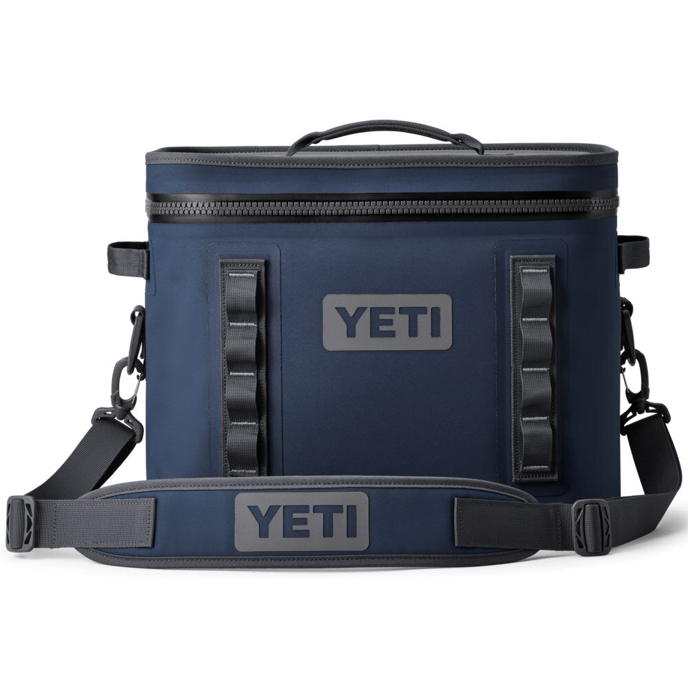 Die YETI® Kühltasche Hopper Flip® 18 in navy verfügt über einen Griff an der Oberseite, einen abnehmbaren Schultergurt, Schlaufen an der Vorderseite und zeigt das YETI-Logo auf der Vorderseite und dem Gurt.