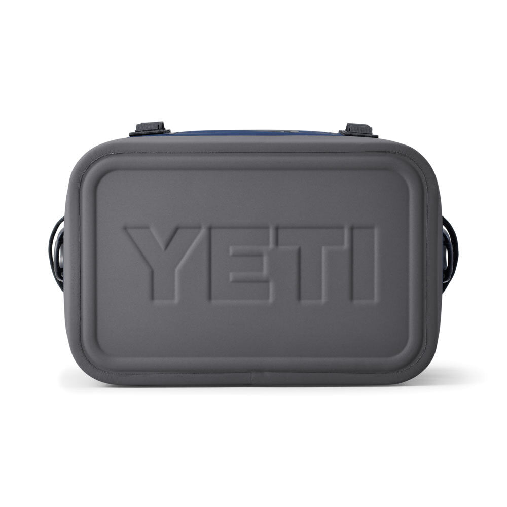 Die rechteckige, marineblaue YETI® Kühltasche Hopper Flip® 18 Soft Cooler Bag ist von vorne abgebildet und zeigt das erhabene YETI-Logo auf der strukturierten Oberfläche sowie schwarze Griffe an beiden Seiten.