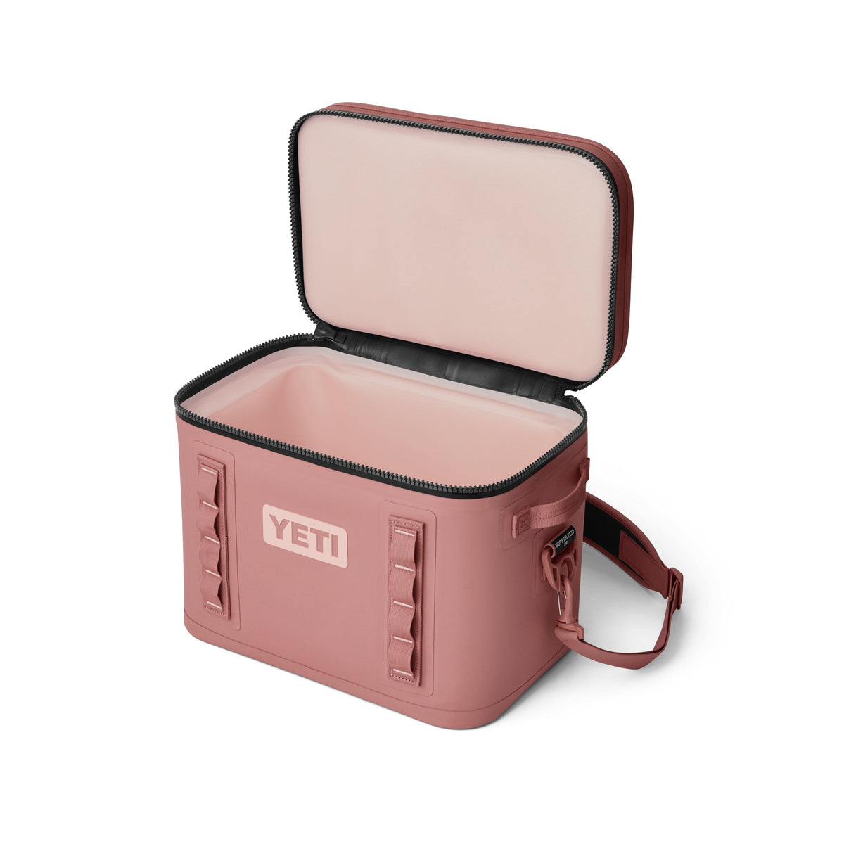Die YETI® Kühltasche Hopper Flip® 18 - Sandstone Pink ist eine weiche Kühltasche mit offenem Deckel, der den Blick auf das leere Innere freigibt. Sie hat einen Schultergurt, ein rechteckiges Design und einen sicheren Reißverschluss.