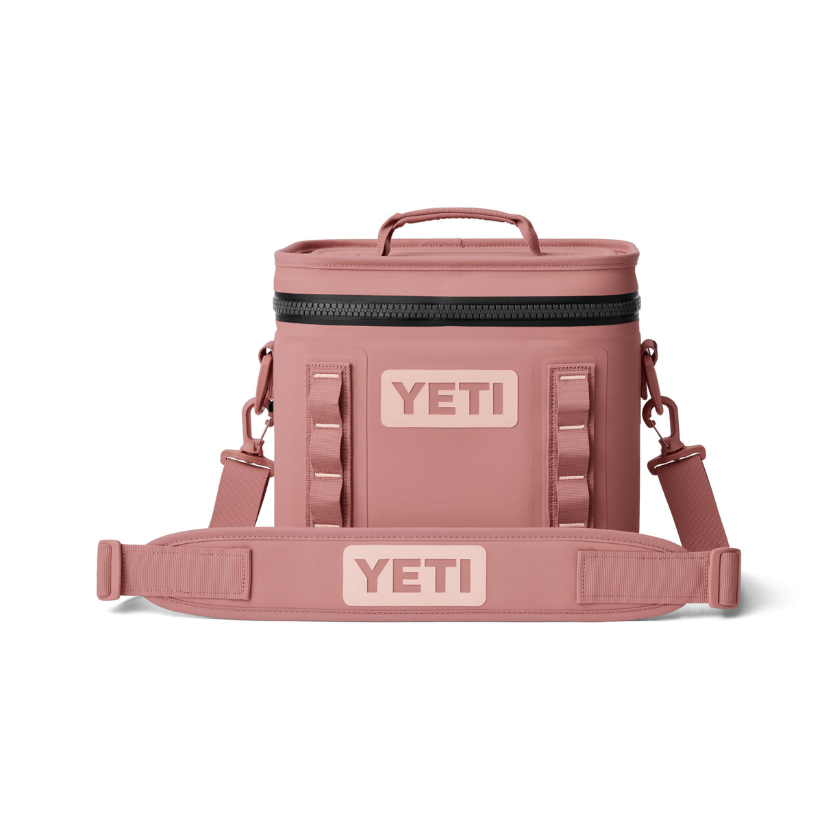 Die YETI® Kühltasche Hopper Flip® 8 in Sandstone Pink hat einen Reißverschlussdeckel, einen stabilen Griff, einen abnehmbaren Schultergurt und zeigt das YETI-Logo in hellem Pink auf der Vorderseite und dem Gurt.