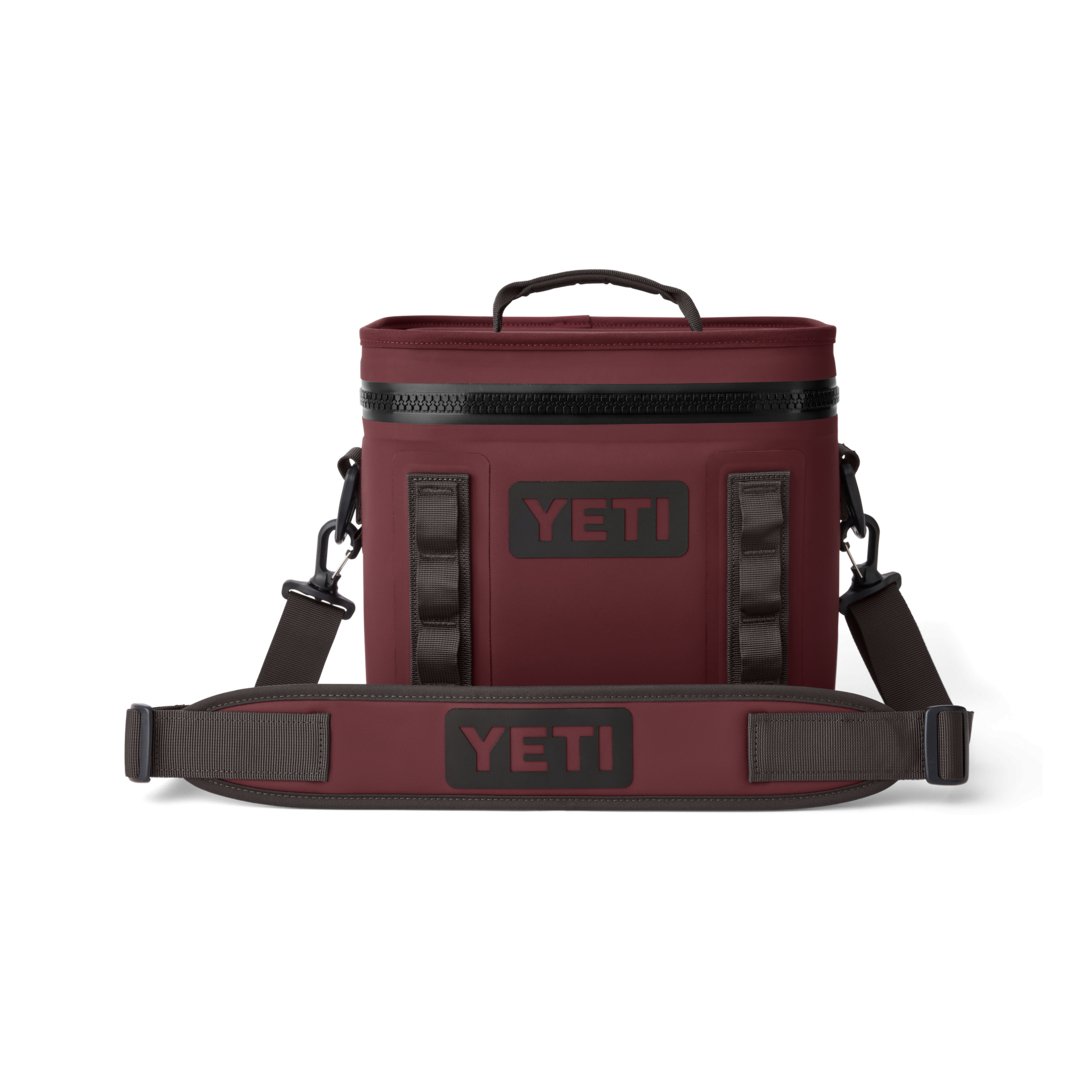 Die YETI® Kühltasche Hopper Flip® 8 in Wild Vine Red verfügt über einen schwarzen Reißverschluss, einen Griff an der Oberseite, einen verstellbaren Schultergurt mit YETI-Branding, seitliche Clips und ein rechteckiges, kastenförmiges Design.