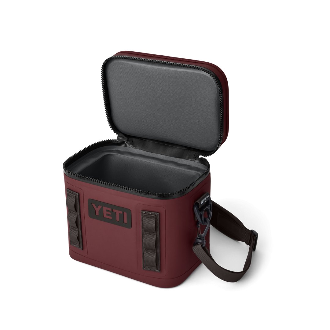 Die YETI® Kühltasche Hopper Flip® 8 in Wild Vine Red verfügt über einen grauen, isolierten Innenraum, einen Reißverschluss, seitliche Tragegurte und einen abnehmbaren Schultergurt - ideal, um Getränke unterwegs kalt zu halten.