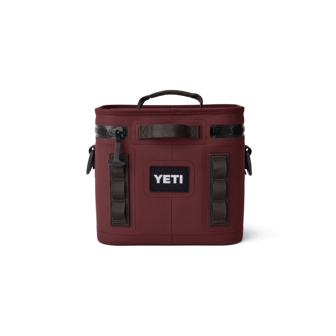 Die YETI® Kühltasche Hopper Flip® 8 in Wild Vine Red verfügt über einen schwarzen Griff, einen Reißverschluss oben, seitliche Schlaufen und ein schwarzes Frontpatch mit dem YETI-Logo auf weißem Hintergrund.