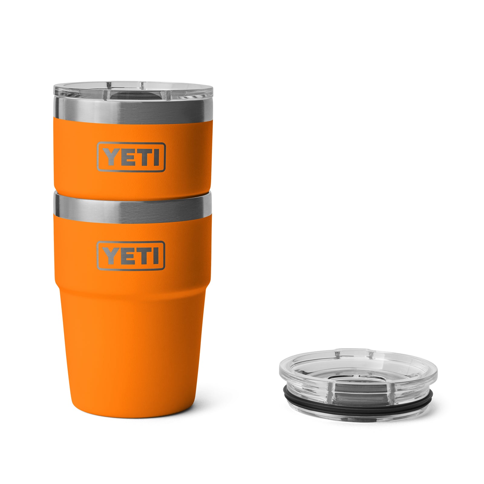Zwei YETI® Rambler 16 Oz Stapelbarer Becher - King Crab von YETI sind gestapelt, mit einem durchsichtigen Plastikdeckel auf der rechten Seite, alles vor einem weißen Hintergrund dargestellt.