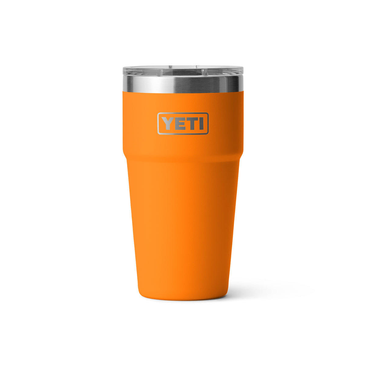 Ein leuchtend orangefarbener YETI® Rambler 20 Oz Stapelbarer Becher - King Crab mit doppelwandiger Vakuumisolierung, klarem Deckel und Edelstahlrand steht aufrecht auf einem schlichten weißen Hintergrund, mit dem YETI Logo auf der Vorderseite.