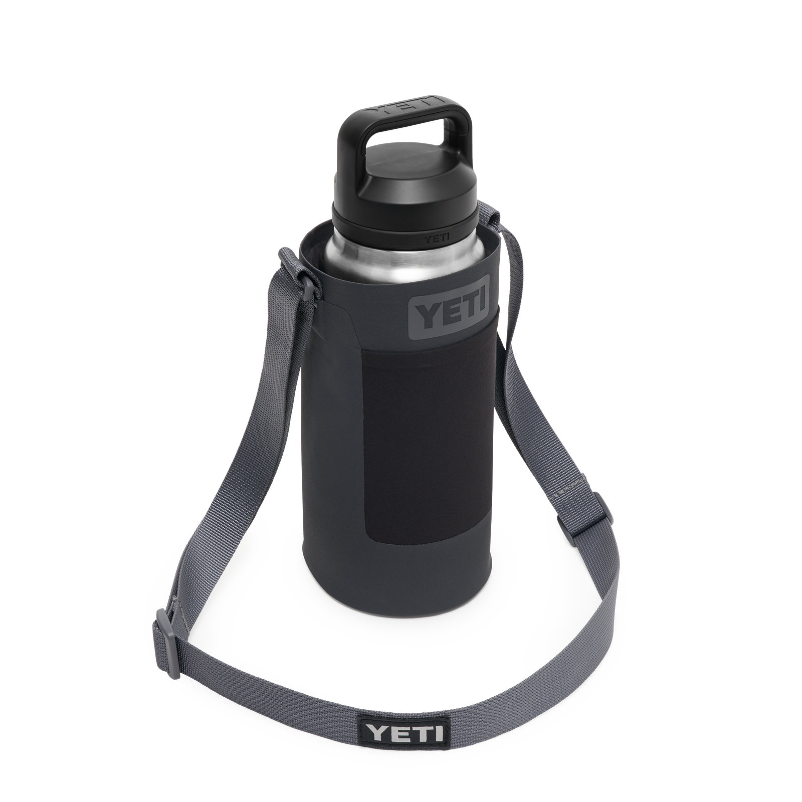 Eine YETI® Rambler Flasche aus rostfreiem Stahl mit schwarzem Deckel befindet sich in der YETI® Rambler Bottle Sling Small in Anthrazit, die einen verstellbaren Schultergurt und das YETI-Logo auf Flasche und Gurt hat.