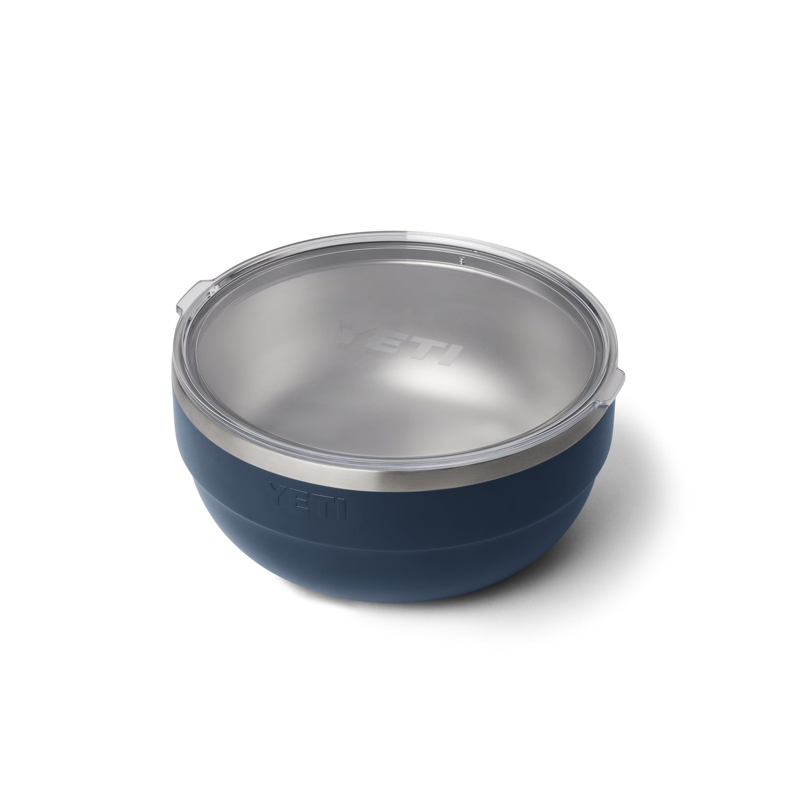 Die YETI® Rambler Bowl Large - Navy ist eine runde 5-Liter-Isolierschüssel mit einem transparenten Kunststoffdeckel, auf dem das YETI-Logo sowohl an der Seite als auch auf dem Deckel eingeprägt ist. Sie ist schräg auf einem weißen Hintergrund abgebildet.