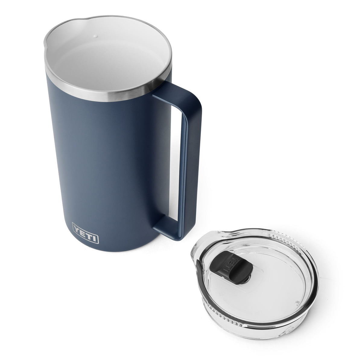 Der YETI® Rambler Pitcher 64 Oz in Navy von YETI ist als vakuumisolierter Edelstahlkrug mit Henkel von oben gezeigt - der transparente Deckel liegt daneben auf weißem Hintergrund.