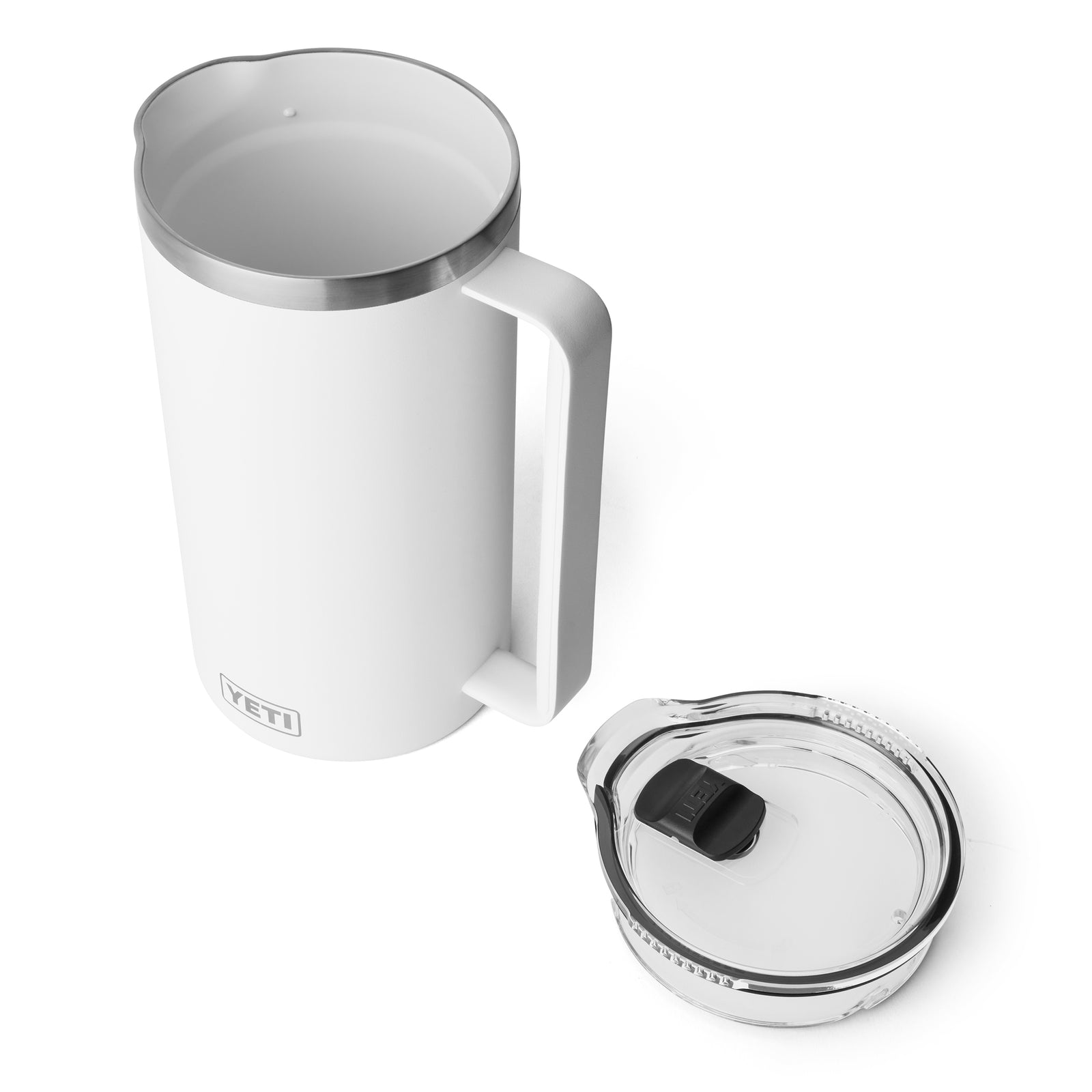 Ein weißer YETI® Rambler Pitcher 64 Oz steht auf einer weißen Oberfläche neben seinem transparenten Deckel und verfügt über einen leicht zu greifenden Griff - ideal, um Getränke während Ihrer Outdoor-Abenteuer kalt zu halten.