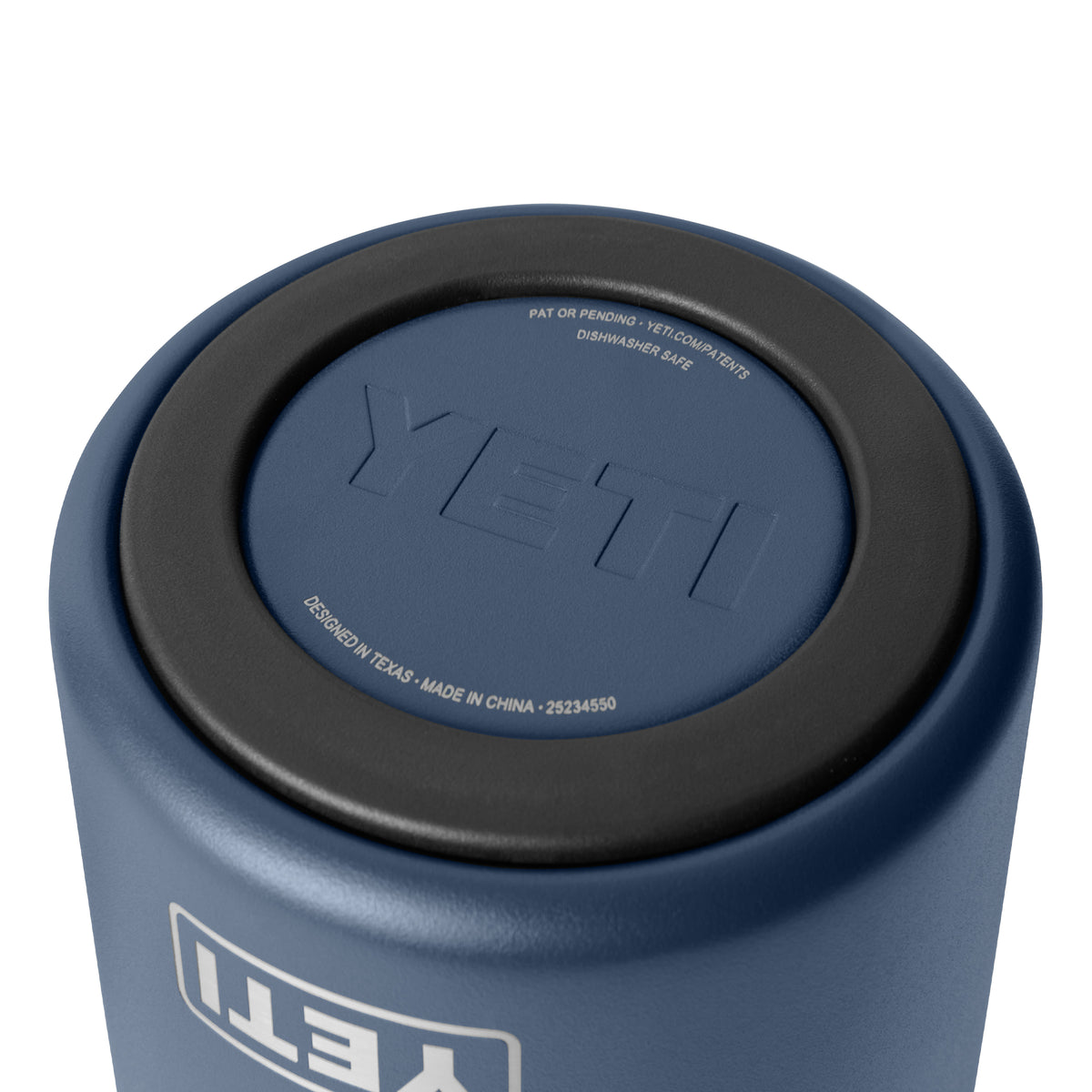 Nahaufnahme des Bodens eines marineblauen YETI® Rambler® Weinkühlers mit dem geprägten YETI-Logo in der Mitte und den in Weiß aufgedruckten Produktdetails auf dem schwarzen Gummiboden.