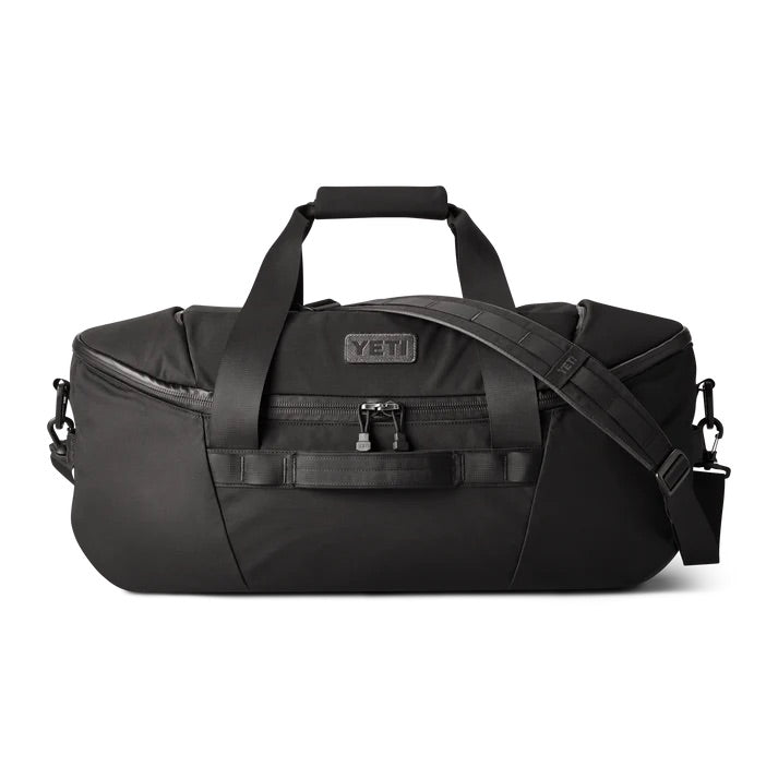 Die YETI® Reisetasche Crossroads 60 L in Schwarz aus robustem TuffSkin-Nylon verfügt über Tragegriffe, einen verstellbaren Schultergurt und eine Fronttasche mit Reißverschluss. Sie wurde von YETI für das Abenteuer gebaut und ist auf einem weißen Hintergrund abgebildet.