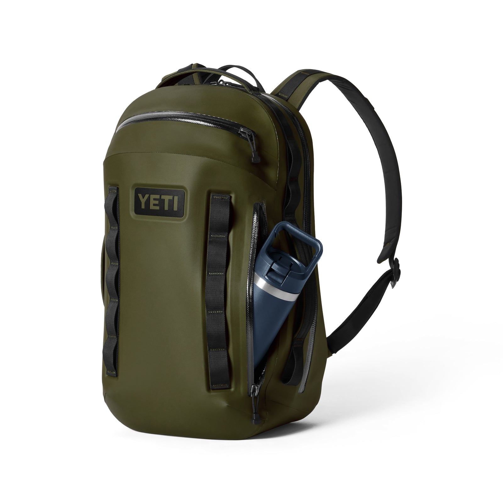 Der YETI® Rucksack Cayo™ 25L - Olive verfügt über schwarze Träger, eine Reißverschlusstasche auf der Vorderseite, eine Seitentasche mit einer blauen Wasserflasche und einen auffälligen YETI-Logoaufnäher, was diesen wetterfesten Rucksack sowohl stilvoll als auch praktisch macht.