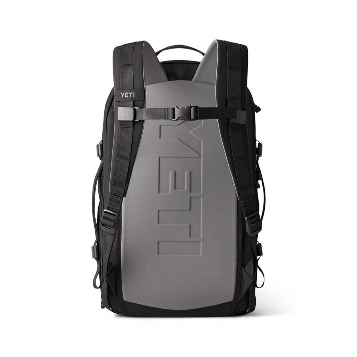 Der YETI® Rucksack Crossroads® 27L - Black ist aufrecht abgebildet und verfügt über verstellbare, gepolsterte Schultergurte, einen Frontclip, eine Rückwand mit YETI-Branding und ein Laptopfach. Sein schlankes Design macht ihn ideal für Outdoor-Abenteuer.