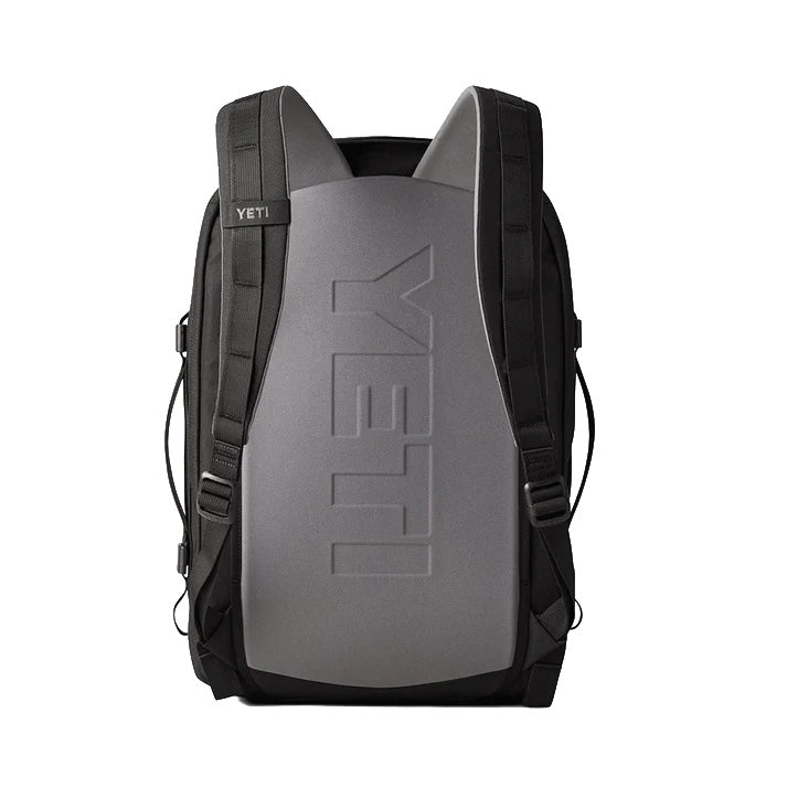 Der YETI® Rucksack Crossroads® 35L - Black verfügt über gepolsterte Gurte, robuste Seiten und ein vertikales YETI-Logo auf der Rückwand. Auf weißem Hintergrund abgebildet.