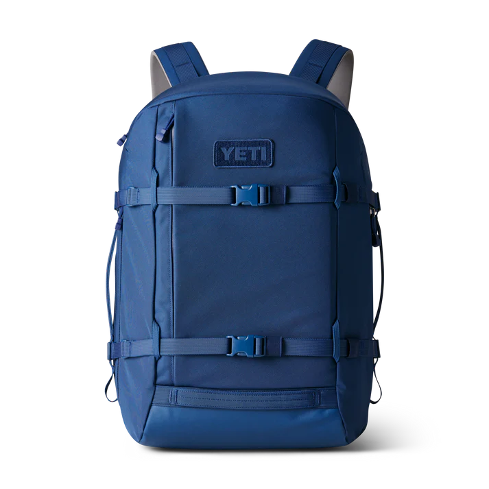 Der YETI® Rucksack Crossroads® 35L in Navy mit verstellbaren Trägern, Seitentaschen und einer Schnalle auf der Vorderseite ist aufrecht vor einem schlichten weißen Hintergrund abgebildet.