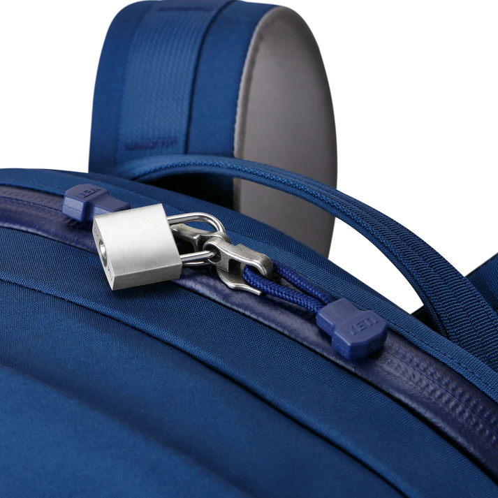 Nahaufnahme des YETI® Rucksack Crossroads® 35L in Navy mit einem silbernen Vorhängeschloss, das die Reißverschlüsse sichert und einen verschlossenen und sicheren Reißverschluss von YETI hervorhebt.