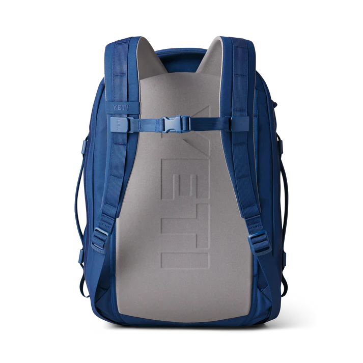 Der YETI® Rucksack Crossroads® 35L in Navy wird von hinten gezeigt, mit verstellbaren Schultergurten und einem gepolsterten grauen Rückenteil mit YETI"-Prägung - ein robuster, zuverlässiger Rucksack für tägliche Abenteuer.