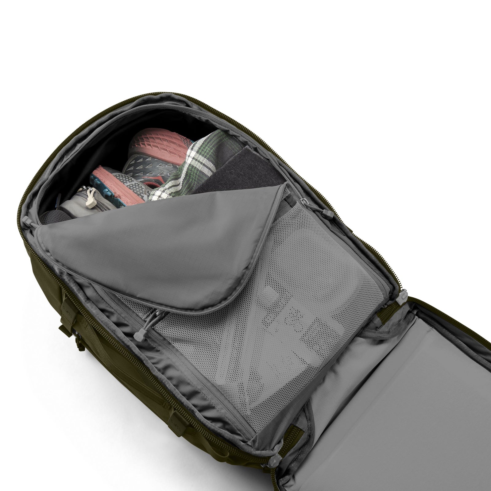 Ein geöffneter YETI® Rucksack Crossroads® 35L - Olive offenbart ordentlich verpackte Schuhe, ein kariertes Hemd, eine schwarze Tasche und Netzfächer mit Reißverschluss für organisierte Aufbewahrung.