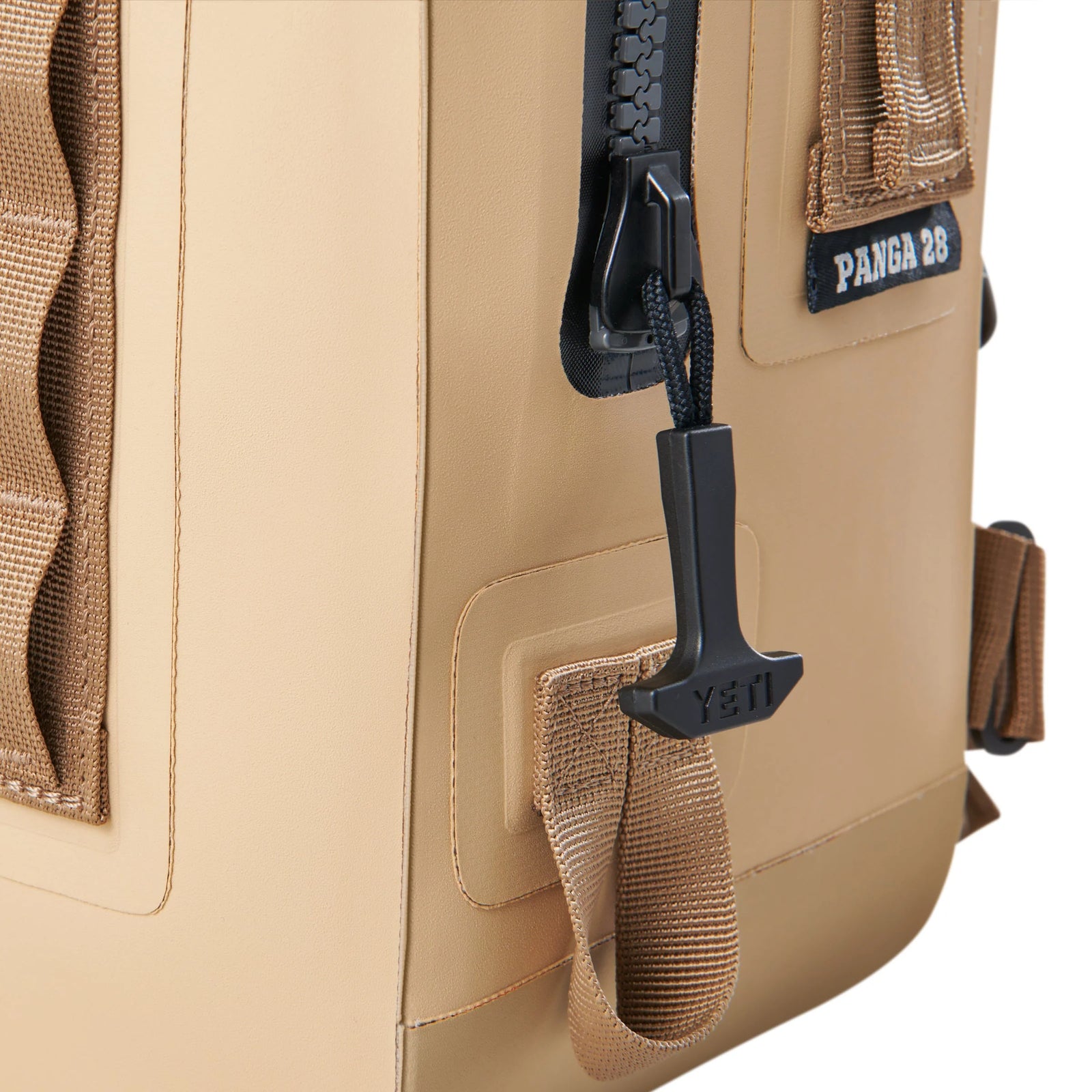 Nahaufnahme des YETI® Rucksack Panga 28 - Tan mit schwarzem Reißverschluss mit YETI-Zuglasche, MOLLE-Gewebe und robustem, strapazierfähigem Außenmaterial - perfekt für Ihre Outdoor-Ausrüstung.