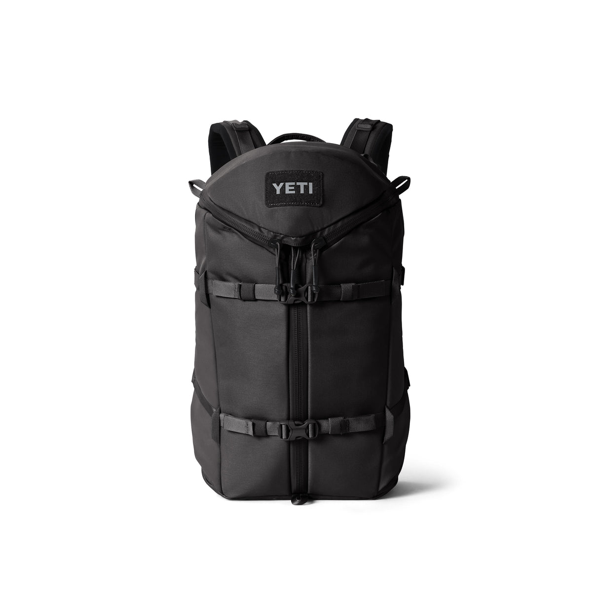 Der YETI® Rucksack Ranchero™ 22L - Black verfügt über gepolsterte Schultergurte, Schnallen an der Vorderseite und eine Klappe mit Reißverschluss, die aufrecht vor einem weißen Hintergrund abgebildet ist.