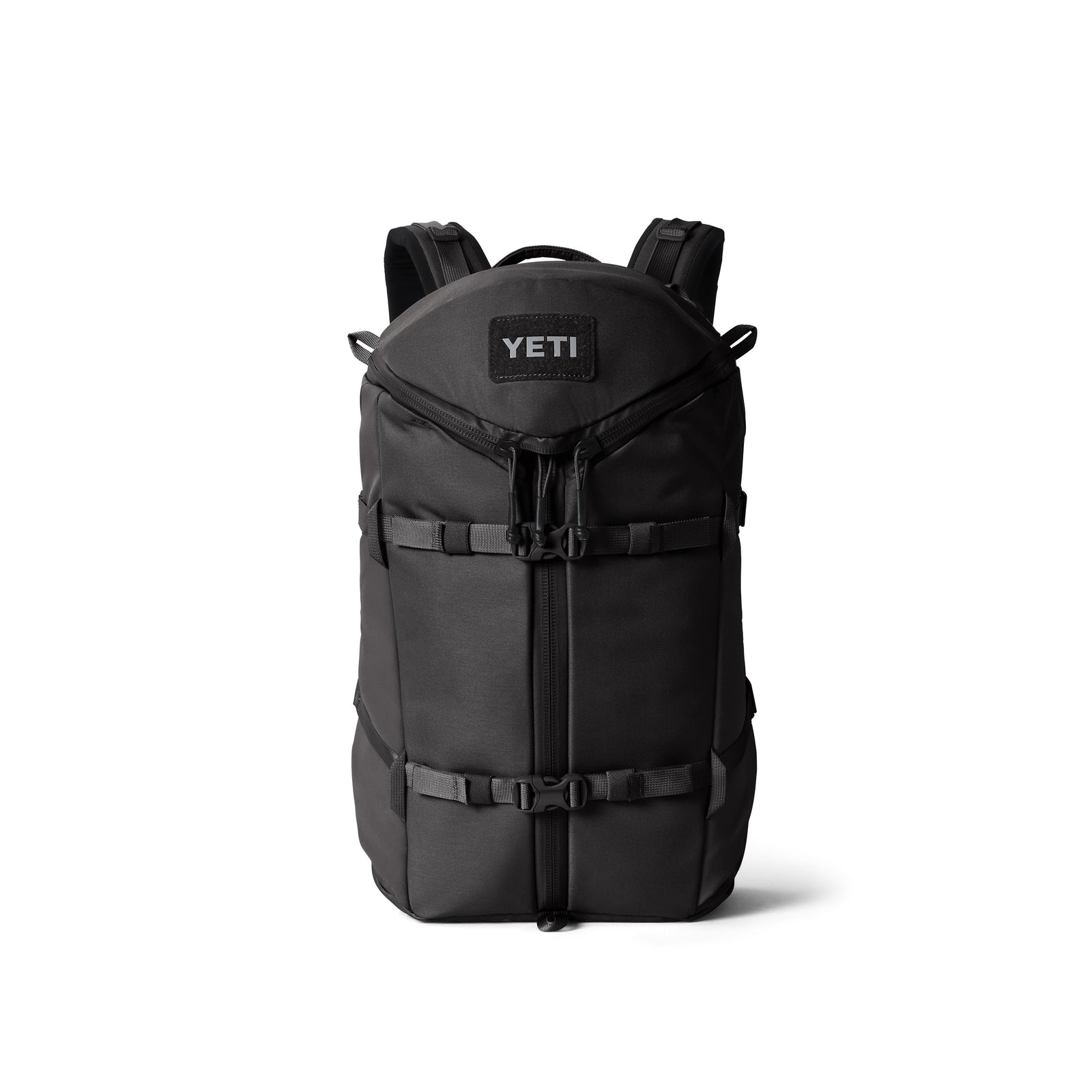 Der YETI® Rucksack Ranchero™ 22L - Black verfügt über gepolsterte Schultergurte, Schnallen an der Vorderseite und eine Klappe mit Reißverschluss, die aufrecht vor einem weißen Hintergrund abgebildet ist.