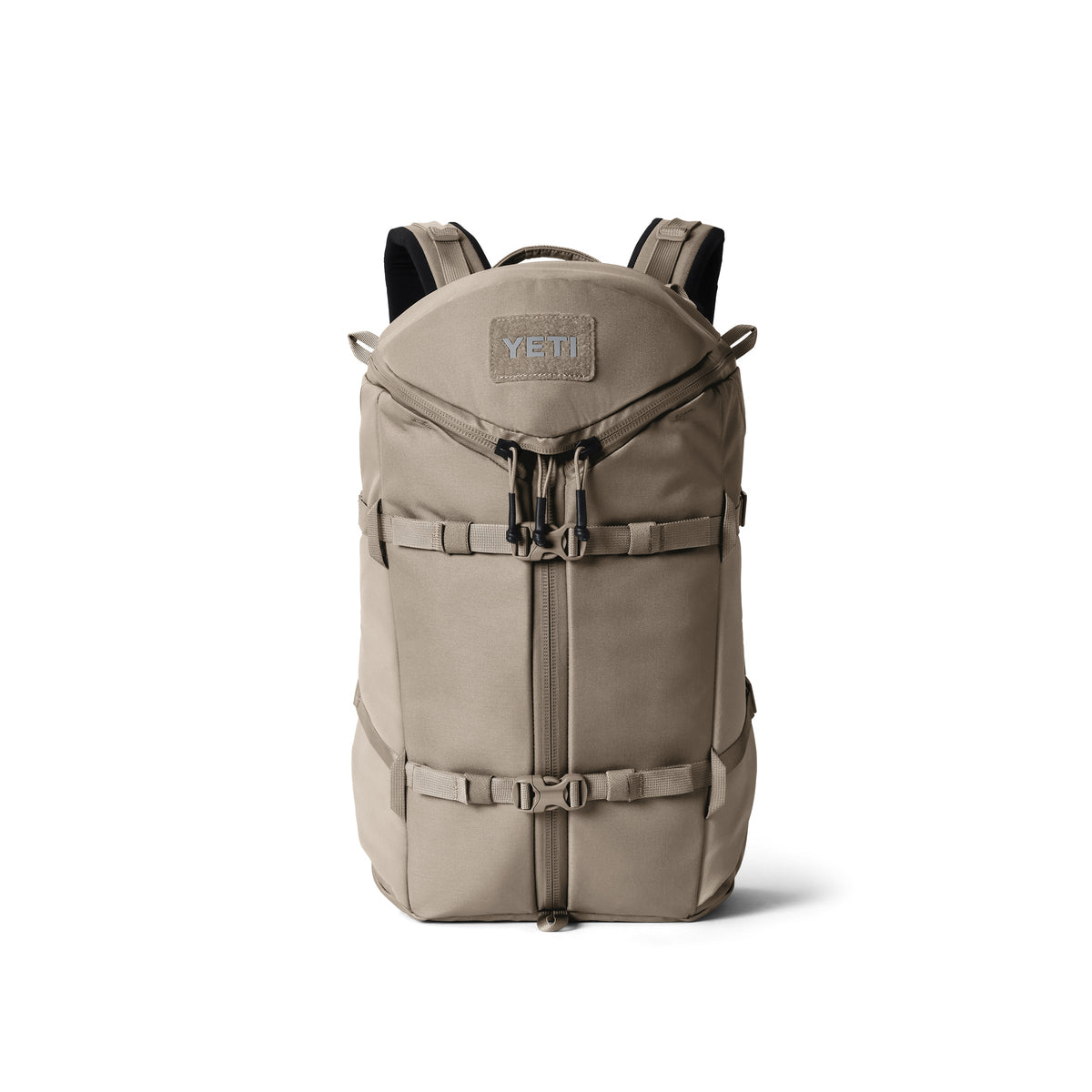 Der YETI® Rucksack Ranchero™ 22L in Cape Dark Taupe verfügt über schwarze Reißverschlüsse, verstellbare Gurte, einen Tragegriff, Schnallengurte an der Vorderseite, einen sichtbaren YETI-Logoaufnäher und ein Laptopfach. Aufrecht vor einem weißen Hintergrund abgebildet.