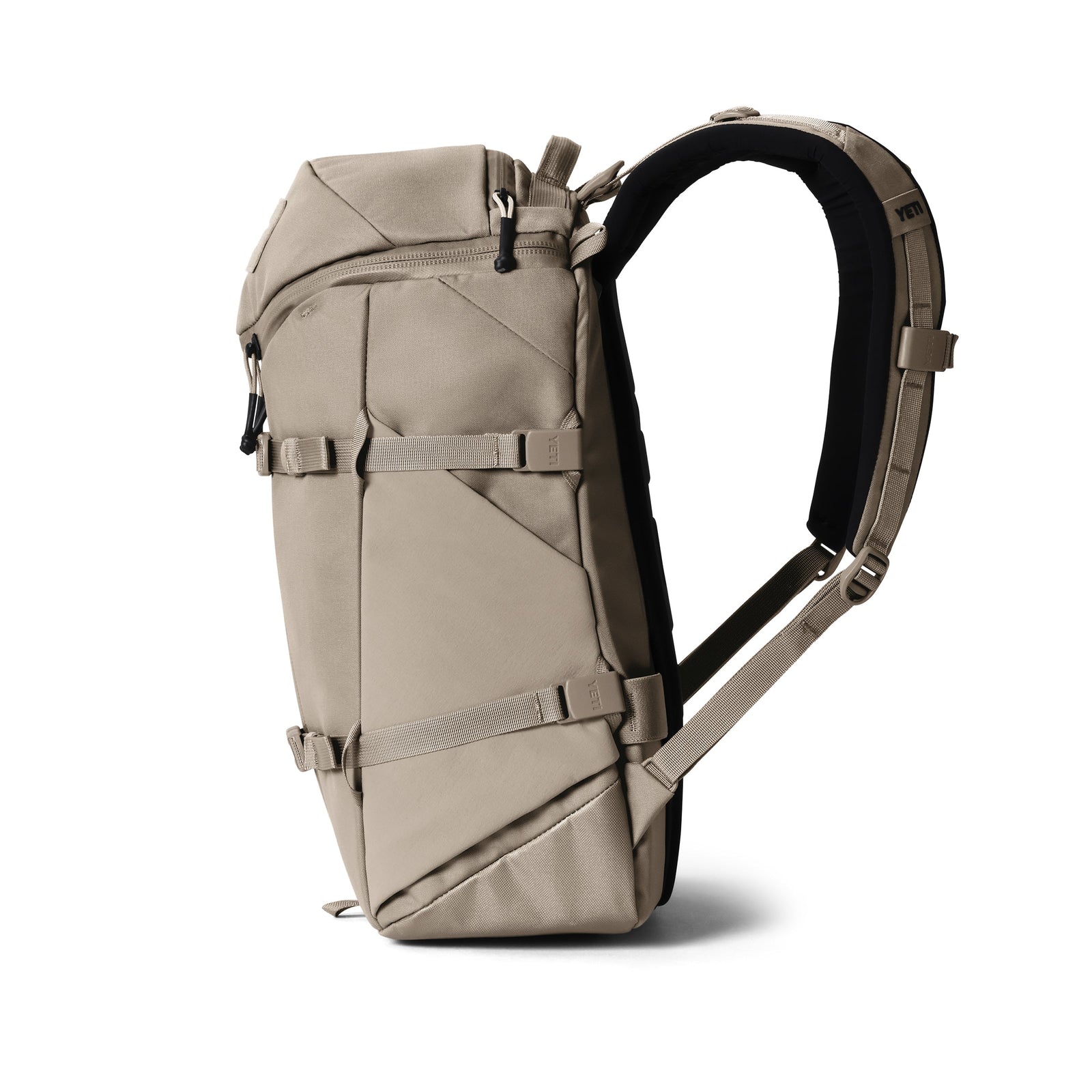 Der YETI® Rucksack Ranchero™ 22L in Cape Dark Taupe steht aufrecht auf weißem Grund, mit geometrischen Linien, verstellbaren Gurten, einem gepolsterten Hüftgurt und einem praktischen Laptop-Fach - perfekt für den täglichen Transport.