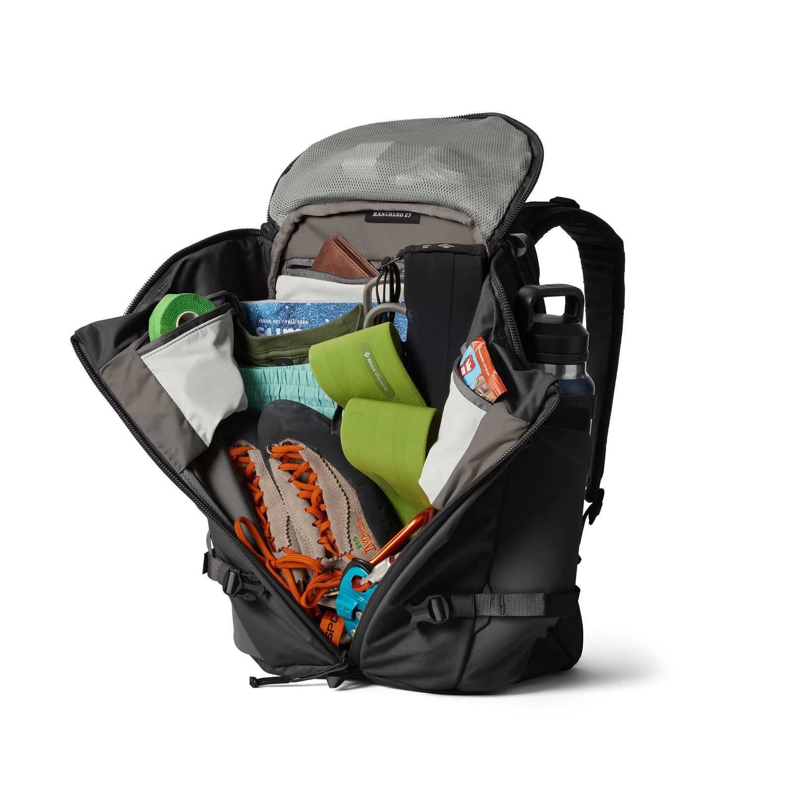 Der YETI® Rucksack Ranchero™ 27L in Schwarz hat eine offene Oberseite und Frontfächer, in denen die wichtigsten Dinge zum Wandern wie Kletterschuhe, eine Wasserflasche, ein Laptopfach, ein orangefarbenes Seil, grüne Taschen und eine blaue Bürste untergebracht sind.