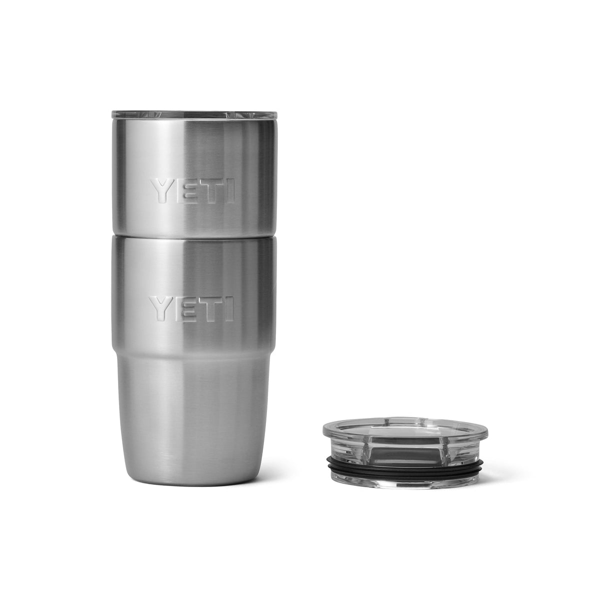 Zwei YETI® Stapelbarer Becher Rambler 8 Oz - Edelstahlbecher von YETI sind zusammen mit einem klaren Kunststoffdeckel daneben auf einem weißen Hintergrund gestapelt, der ihr vakuumisoliertes Design hervorhebt.