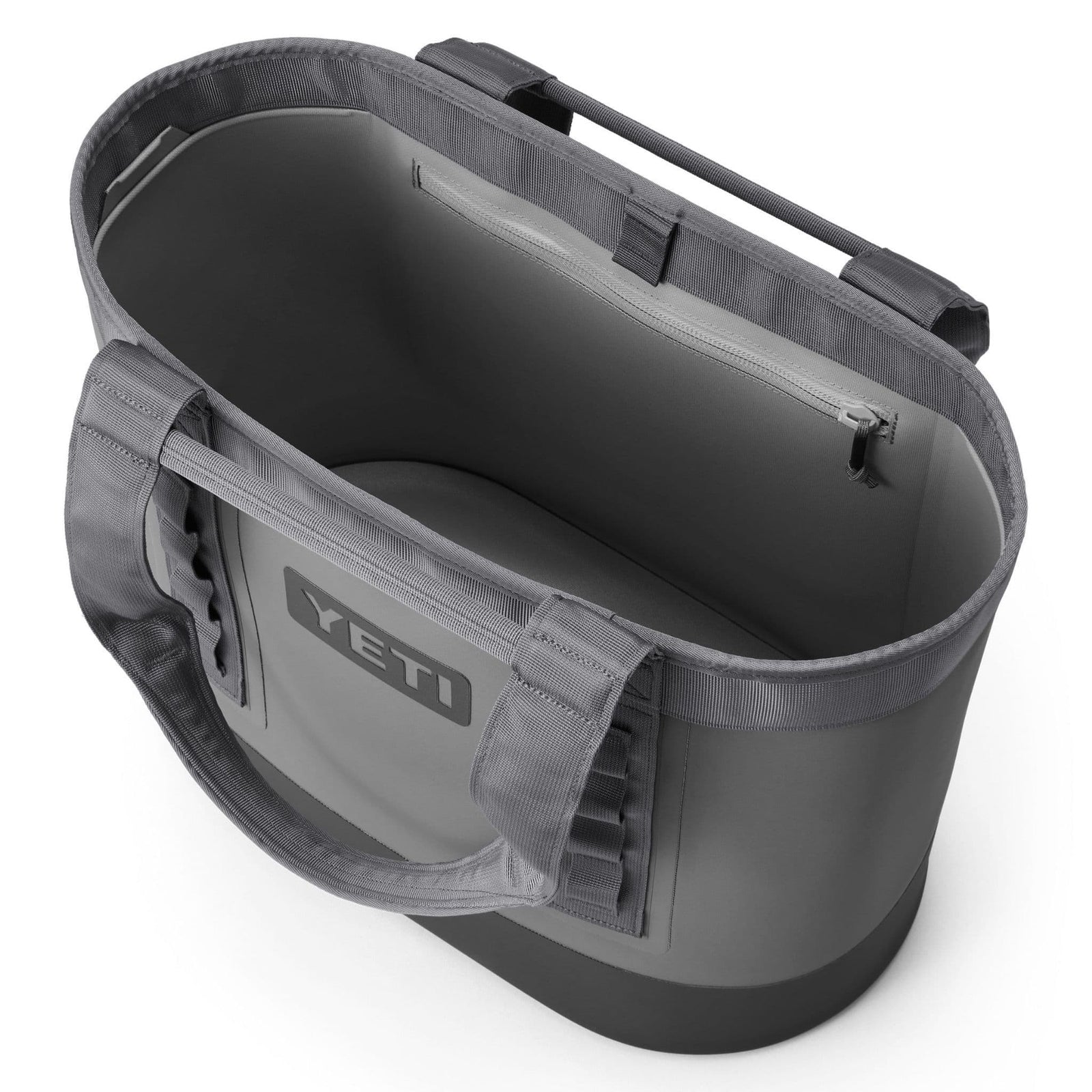 Die Draufsicht auf die YETI® Tragetasche Camino® Carryall 50 - Storm Grey zeigt große Griffe, ein offenes Hauptfach, ein Innenfach mit Reißverschluss und das wasserdichte YETI-Logo auf der Vorderseite.