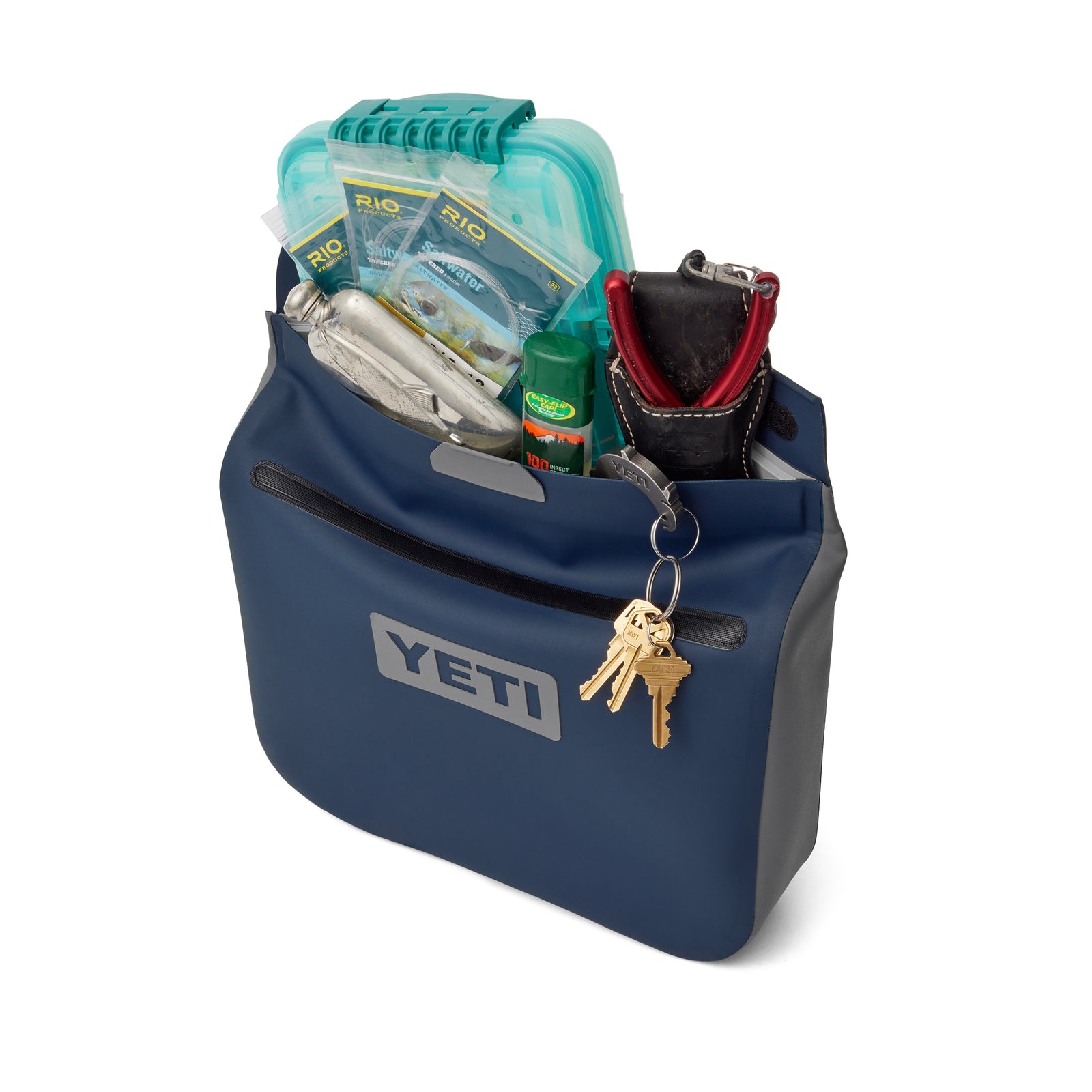Die navyfarbene YETI® Zubehörtasche - Sidekick® 6L von YETI bietet Platz für Outdoor-Ausrüstung wie eine Tasche, ein Multitool, Fliegenfischerpeitschen, ein Feuerzeug, Insektenschutzmittel, eine Pinzette und Schlüssel, die am vorderen Reißverschluss befestigt sind.